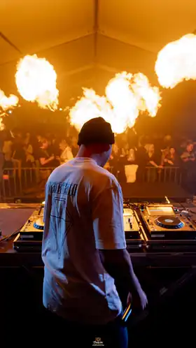 MARK TARRO at the DJ booth with audience and flame effects